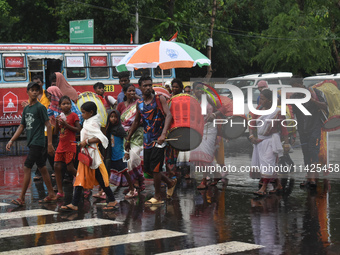 People are walking on the street in the rain in Kolkata, India, on July 21, 2024. (