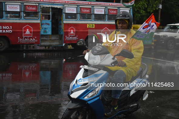 A person is riding a scooter in the rain in Kolkata, India, on July 21, 2024. 