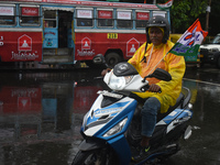 A person is riding a scooter in the rain in Kolkata, India, on July 21, 2024. (