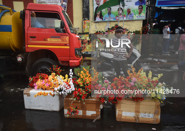 A person is selling plastic flowers during the monsoon in Kolkata, India, on July 21, 2024. 