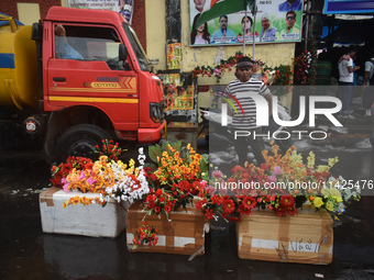 A person is selling plastic flowers during the monsoon in Kolkata, India, on July 21, 2024. (