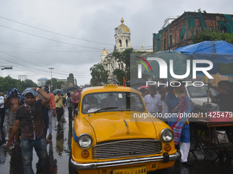 People are walking on the street in the rain in Kolkata, India, on July 21, 2024. (