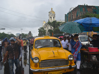 People are walking on the street in the rain in Kolkata, India, on July 21, 2024. (