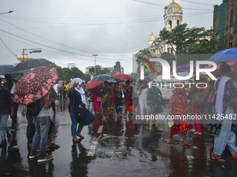 People are walking on the street in the rain in Kolkata, India, on July 21, 2024. (