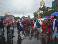 People are walking on the street in the rain in Kolkata, India, on July 21, 2024. (