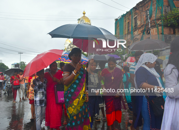 Women are using umbrellas while walking on the street during the monsoon in Kolkata, India, on July 21, 2024. 