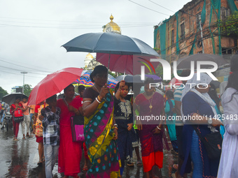 Women are using umbrellas while walking on the street during the monsoon in Kolkata, India, on July 21, 2024. (