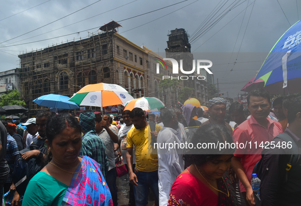 People are walking on the street during heavy cloudy weather in Kolkata, India, on July 21, 2024. 