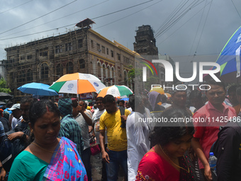 People are walking on the street during heavy cloudy weather in Kolkata, India, on July 21, 2024. (