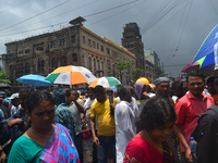 People are walking on the street during heavy cloudy weather in Kolkata, India, on July 21, 2024. (