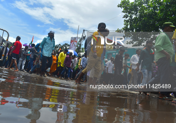 People are walking on the stuck water after heavy rain in Kolkata, India, on July 21, 2024. 