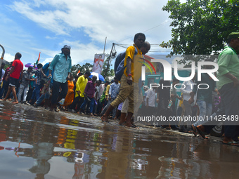 People are walking on the stuck water after heavy rain in Kolkata, India, on July 21, 2024. (