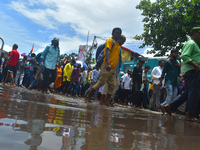 People are walking on the stuck water after heavy rain in Kolkata, India, on July 21, 2024. (