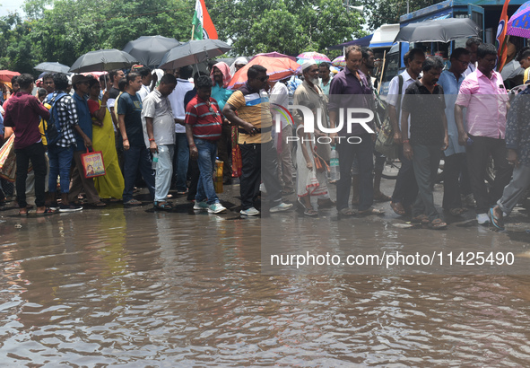 People are walking on the stuck water after heavy rain in Kolkata, India, on July 21, 2024. 