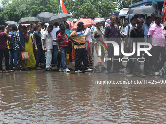 People are walking on the stuck water after heavy rain in Kolkata, India, on July 21, 2024. (