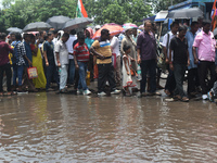 People are walking on the stuck water after heavy rain in Kolkata, India, on July 21, 2024. (