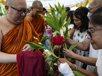 Thais are offering flowers to Buddhist monks during a floral merit-making ceremony, known as 'tak bat dok mai', at Rama IX Golden Jubilee Te...