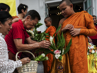 Thais are offering flowers to Buddhist monks during a floral merit-making ceremony, known as 'tak bat dok mai', at Rama IX Golden Jubilee Te...