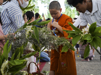 Thais are offering flowers to Buddhist monks during a floral merit-making ceremony, known as 'tak bat dok mai', at Rama IX Golden Jubilee Te...