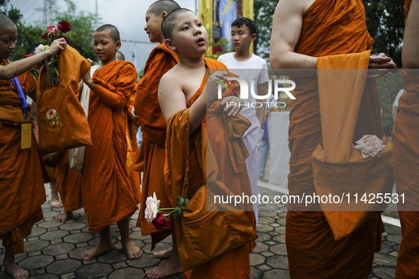 Buddhist monks are joining during a floral merit-making ceremony, known as 'tak bat dok mai', at Rama IX Golden Jubilee Temple in Bangkok, T...