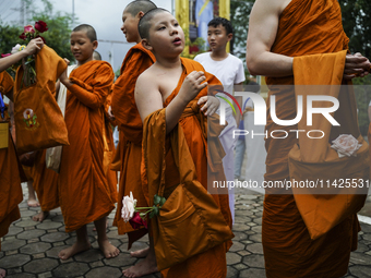 Buddhist monks are joining during a floral merit-making ceremony, known as 'tak bat dok mai', at Rama IX Golden Jubilee Temple in Bangkok, T...