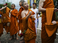 Buddhist monks are joining during a floral merit-making ceremony, known as 'tak bat dok mai', at Rama IX Golden Jubilee Temple in Bangkok, T...