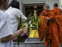 Thais are offering flowers to Buddhist monks during a floral merit-making ceremony, known as 'tak bat dok mai', at Rama IX Golden Jubilee Te...