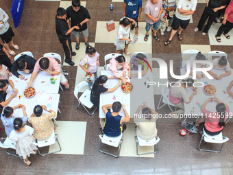 Citizens are taking part in an activity to ''eat shrimp'' at a commercial center in Huai'an city, Jiangsu province, China, on July 21, 2024....