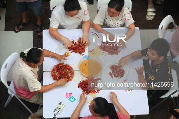 Citizens are taking part in an activity to ''eat shrimp'' at a commercial center in Huai'an city, Jiangsu province, China, on July 21, 2024....