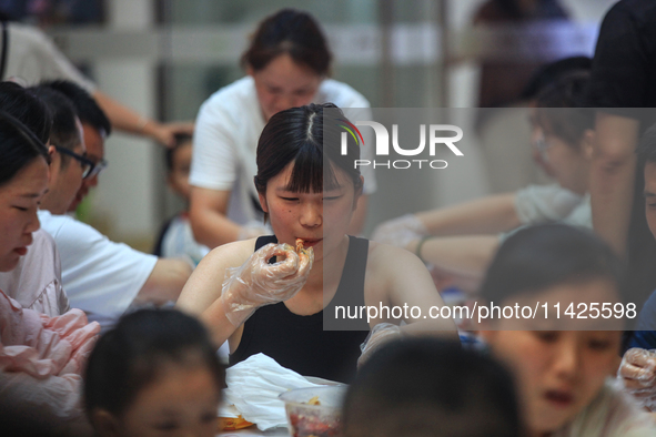 Citizens are taking part in an activity to ''eat shrimp'' at a commercial center in Huai'an city, Jiangsu province, China, on July 21, 2024....