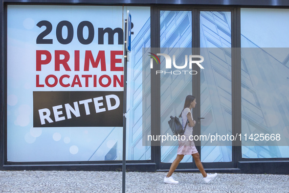 People are seen walking by a closed storefront in Lisbon, Portugal, on July 21, 2024. An interruption of Microsoft systems, related to the c...