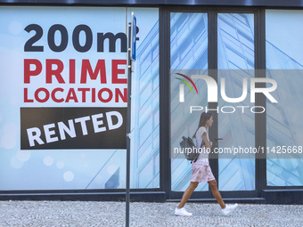 People are seen walking by a closed storefront in Lisbon, Portugal, on July 21, 2024. An interruption of Microsoft systems, related to the c...