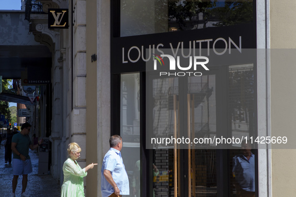 People are walking by the Louis Vuitton storefront building in Lisbon, Portugal, on July 21, 2024. An interruption of Microsoft systems, rel...