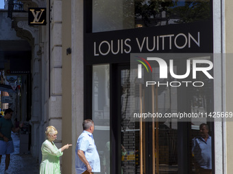 People are walking by the Louis Vuitton storefront building in Lisbon, Portugal, on July 21, 2024. An interruption of Microsoft systems, rel...