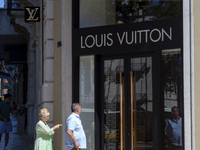 People are walking by the Louis Vuitton storefront building in Lisbon, Portugal, on July 21, 2024. An interruption of Microsoft systems, rel...