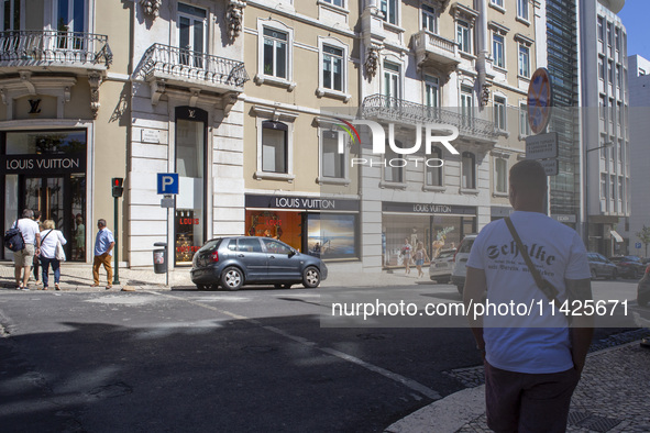 People are walking by the Louis Vuitton storefront building in Lisbon, Portugal, on July 21, 2024. An interruption of Microsoft systems, rel...