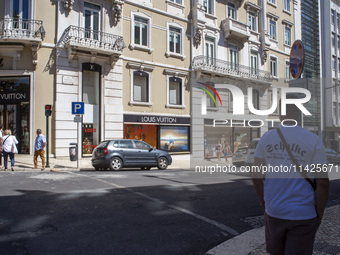 People are walking by the Louis Vuitton storefront building in Lisbon, Portugal, on July 21, 2024. An interruption of Microsoft systems, rel...