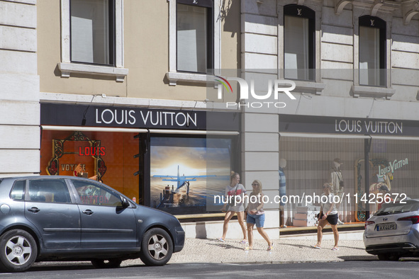 People are walking by the Louis Vuitton storefront building in Lisbon, Portugal, on July 21, 2024. An interruption of Microsoft systems, rel...