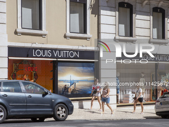 People are walking by the Louis Vuitton storefront building in Lisbon, Portugal, on July 21, 2024. An interruption of Microsoft systems, rel...