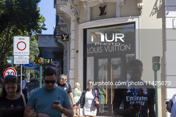 People are walking by the Louis Vuitton storefront building in Lisbon, Portugal, on July 21, 2024. An interruption of Microsoft systems, rel...