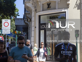 People are walking by the Louis Vuitton storefront building in Lisbon, Portugal, on July 21, 2024. An interruption of Microsoft systems, rel...