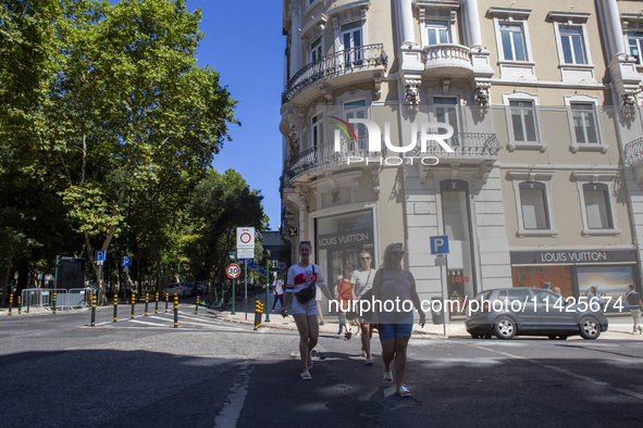 People are walking by the Louis Vuitton storefront building in Lisbon, Portugal, on July 21, 2024. An interruption of Microsoft systems, rel...