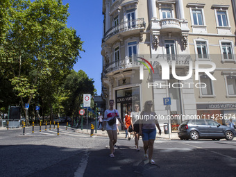 People are walking by the Louis Vuitton storefront building in Lisbon, Portugal, on July 21, 2024. An interruption of Microsoft systems, rel...