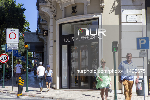 People are walking by the Louis Vuitton storefront building in Lisbon, Portugal, on July 21, 2024. An interruption of Microsoft systems, rel...