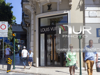 People are walking by the Louis Vuitton storefront building in Lisbon, Portugal, on July 21, 2024. An interruption of Microsoft systems, rel...