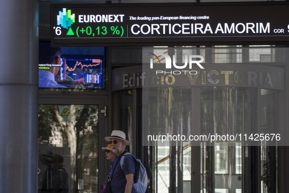 People are walking by the Lisbon Stock Exchange building in Lisbon, Portugal, on July 21, 2024. An interruption of Microsoft systems, relate...