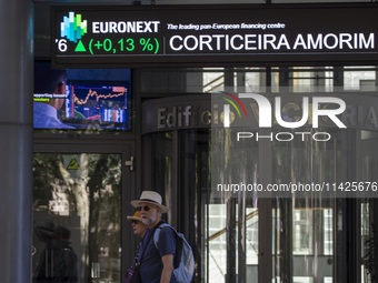 People are walking by the Lisbon Stock Exchange building in Lisbon, Portugal, on July 21, 2024. An interruption of Microsoft systems, relate...