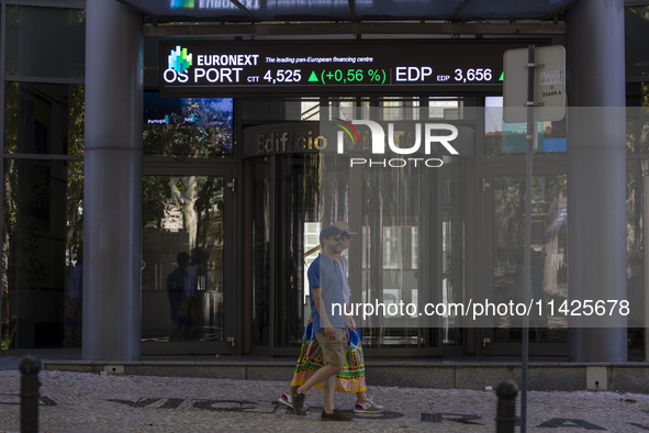 People are walking by the Lisbon Stock Exchange building in Lisbon, Portugal, on July 21, 2024. An interruption of Microsoft systems, relate...