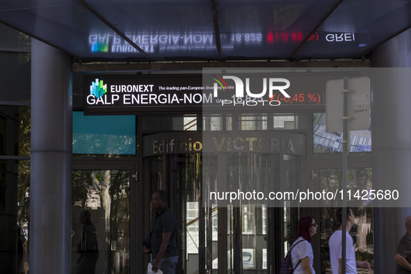 People are walking by the Lisbon Stock Exchange building in Lisbon, Portugal, on July 21, 2024. An interruption of Microsoft systems, relate...