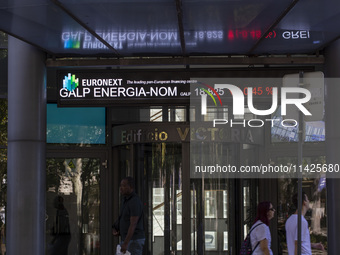 People are walking by the Lisbon Stock Exchange building in Lisbon, Portugal, on July 21, 2024. An interruption of Microsoft systems, relate...